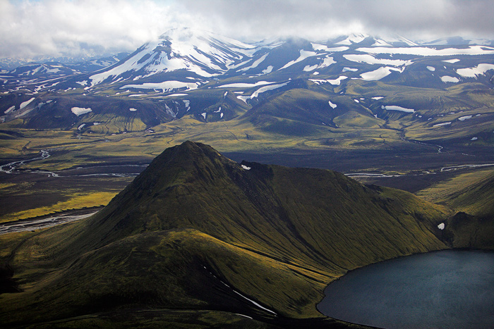 Volcanos A lake forms in the crater of an extinct volcano in the foreground. In the distance are the lower slopes of Mount Hekla, an active...